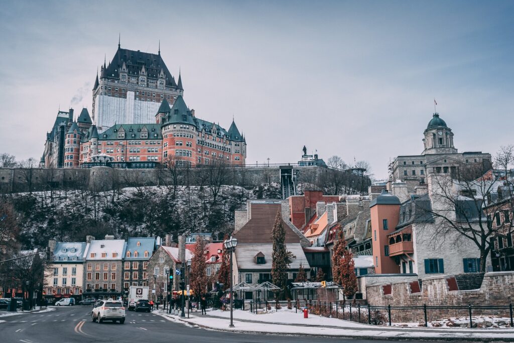 Scenic view of Quebec City with a castle, highlighting the city's historic charm and architecture. In the foreground, a bottle of CBD oil Canada is placed, symbolizing the region's progressive approach to wellness and natural remedies. The image captures the harmonious blend of Quebec's ancient beauty and its embrace of modern health trends